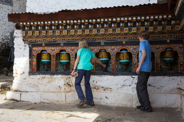 Two kids by the Spinning Prayer Wheels in the Cheri Monastery in Bhutan.