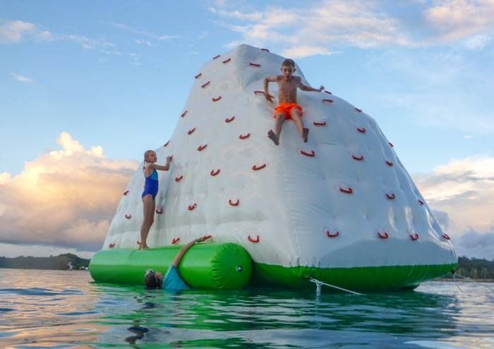 Tyler and Kara on a floating climbing wall in the ocean in Fiji.