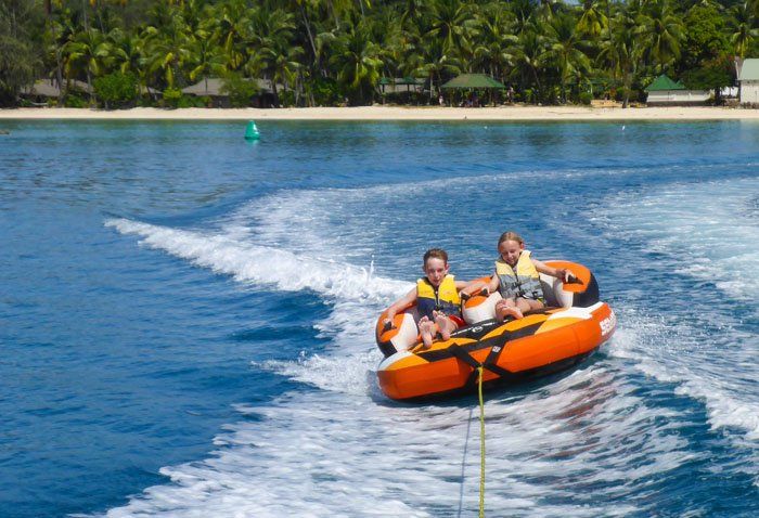 Tyler and Kara on a floating raft being pulled by a speedboat in Fiji.