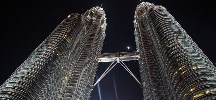a low angle view of a tall building with Petronas Towers in the background