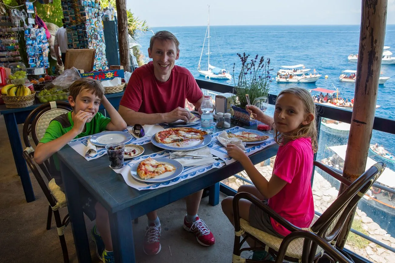Tyler Tim and Kara eating lunch at a cafe overlooking the Blue Grotto rowboats