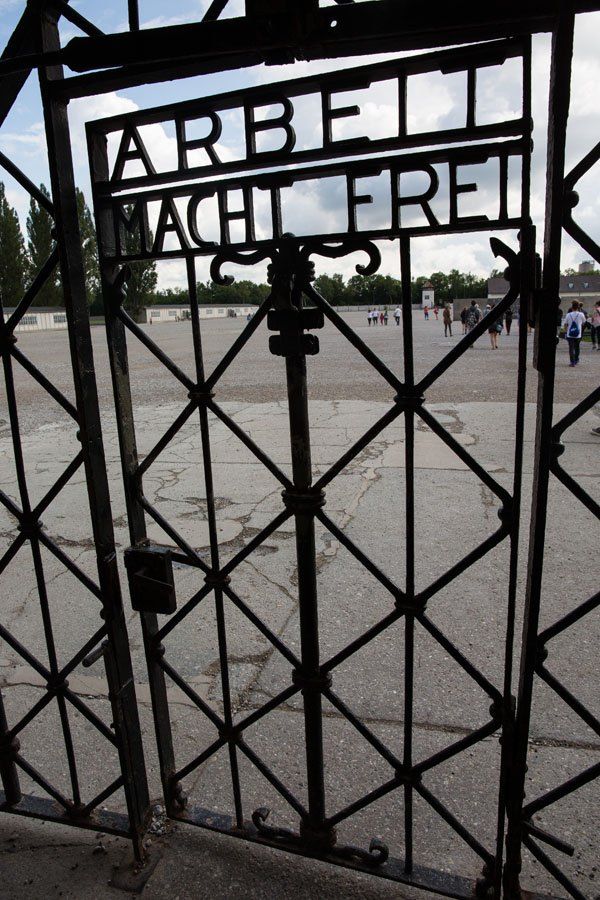 A black-colored door made of iron bars. It reads "Arbeit Macht Frei" (Work sets your free).