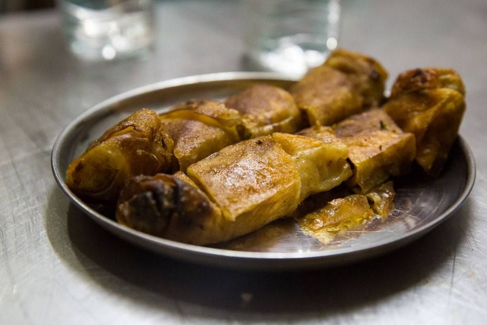 Chicken rolls being enjoyed at a small street food restaurant in Mumbai.