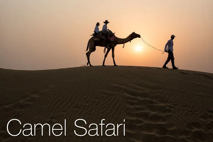 A couple enjoying a camel ride in the desert.
