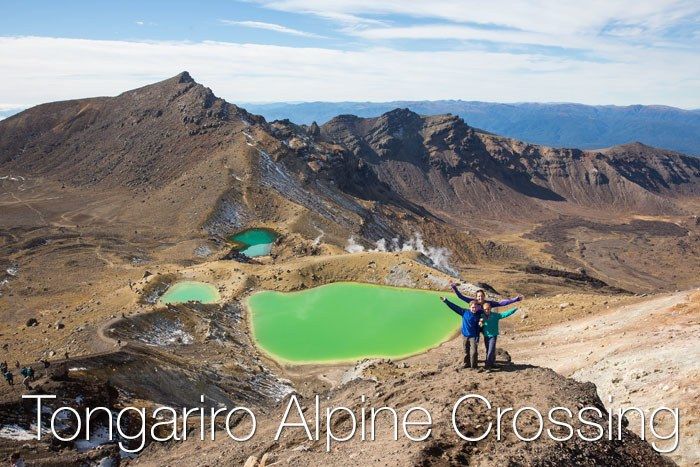 Dry and barren landscape at the Tongariro Alpine Crossing with small, acid-green water bodies.