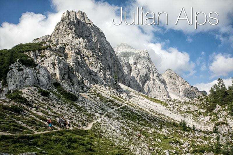 A group of hikers trekking with a small mountain the background in Julian Alps, Slovenia.
