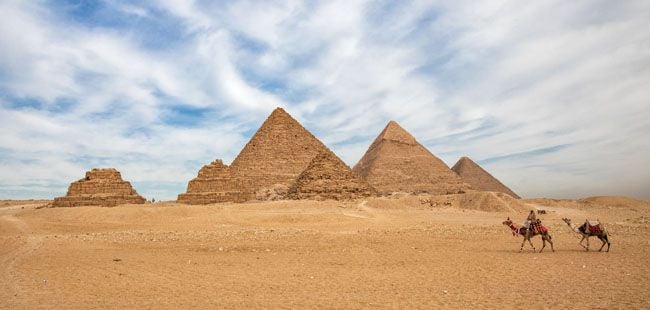 a group of pyramids in a desert with Giza pyramid complex in the background