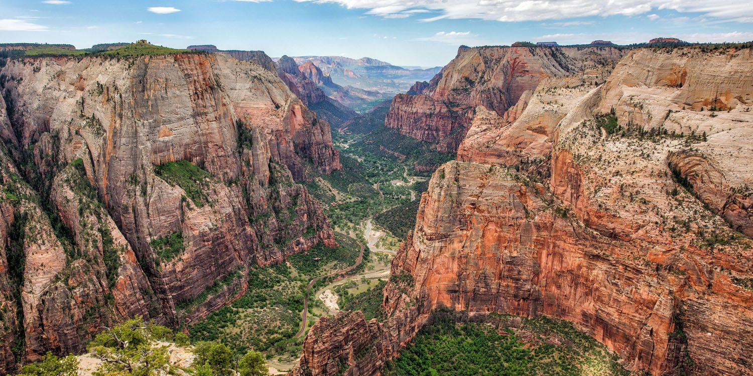 a canyon with a river in the middle with Zion National Park in the background