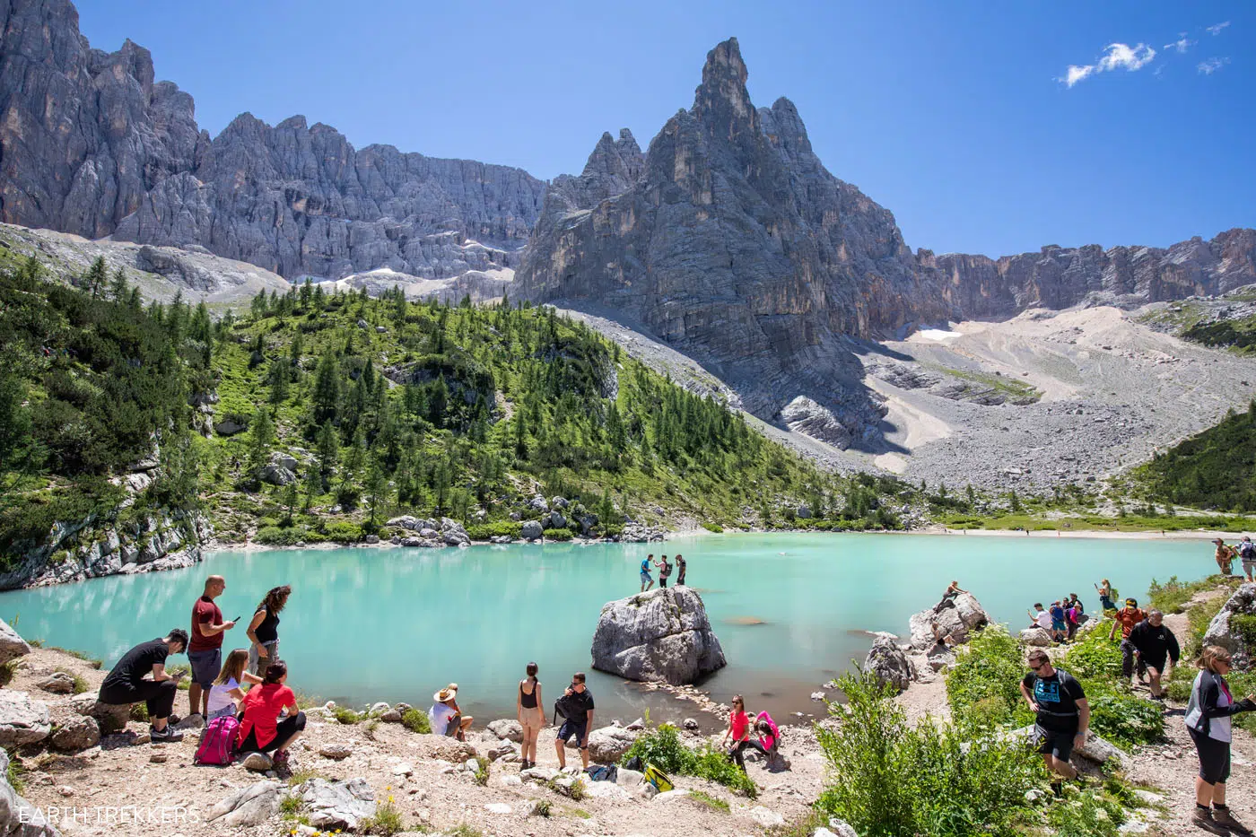 Photo of Lago Sorapis in July with hikers on the shore