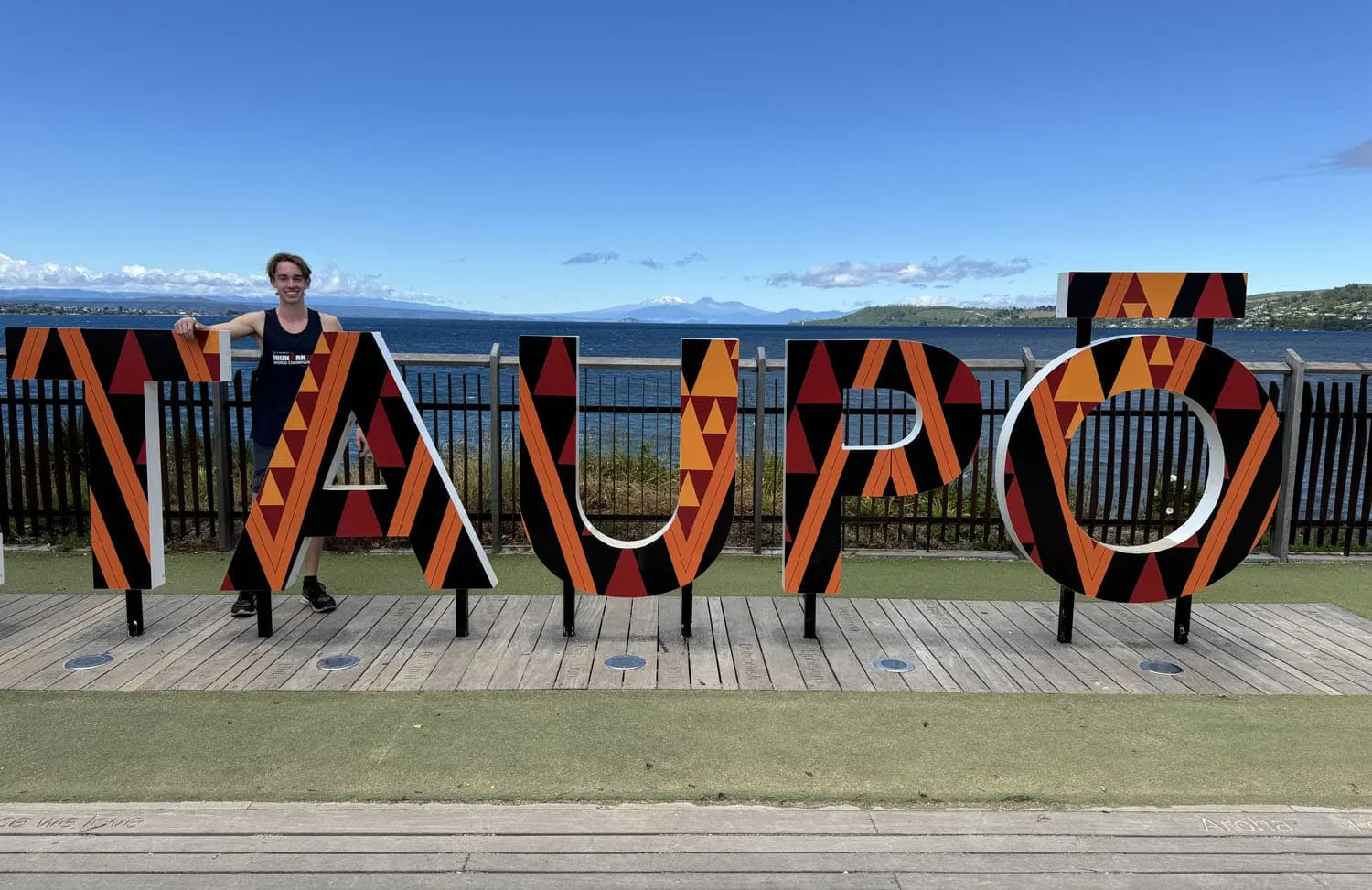 Tyler in front of the Taupo New Zealand Sign during the IRONMAN 70.3 World Championships.
